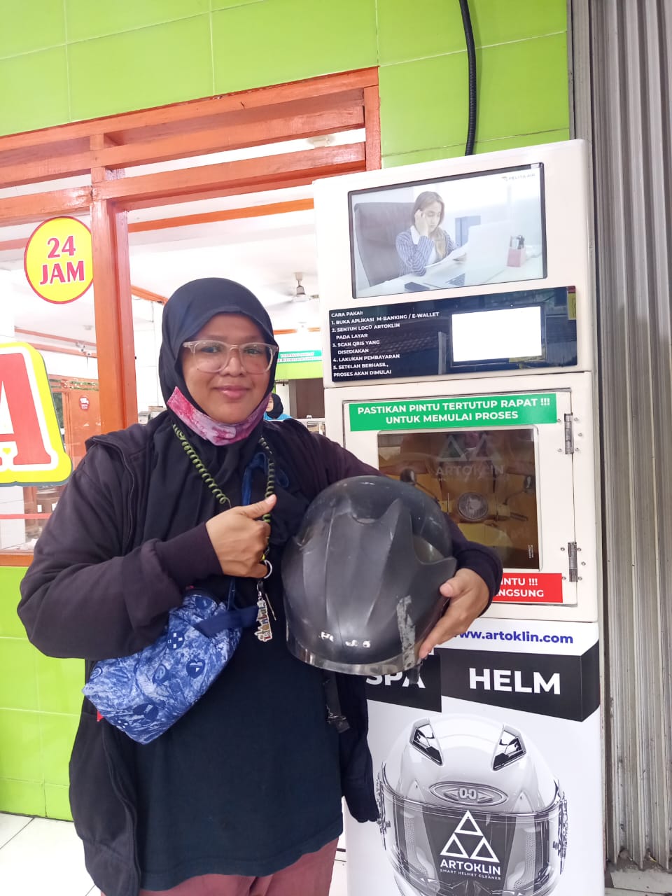 Rider holding a helmet beside the Artoklin machine